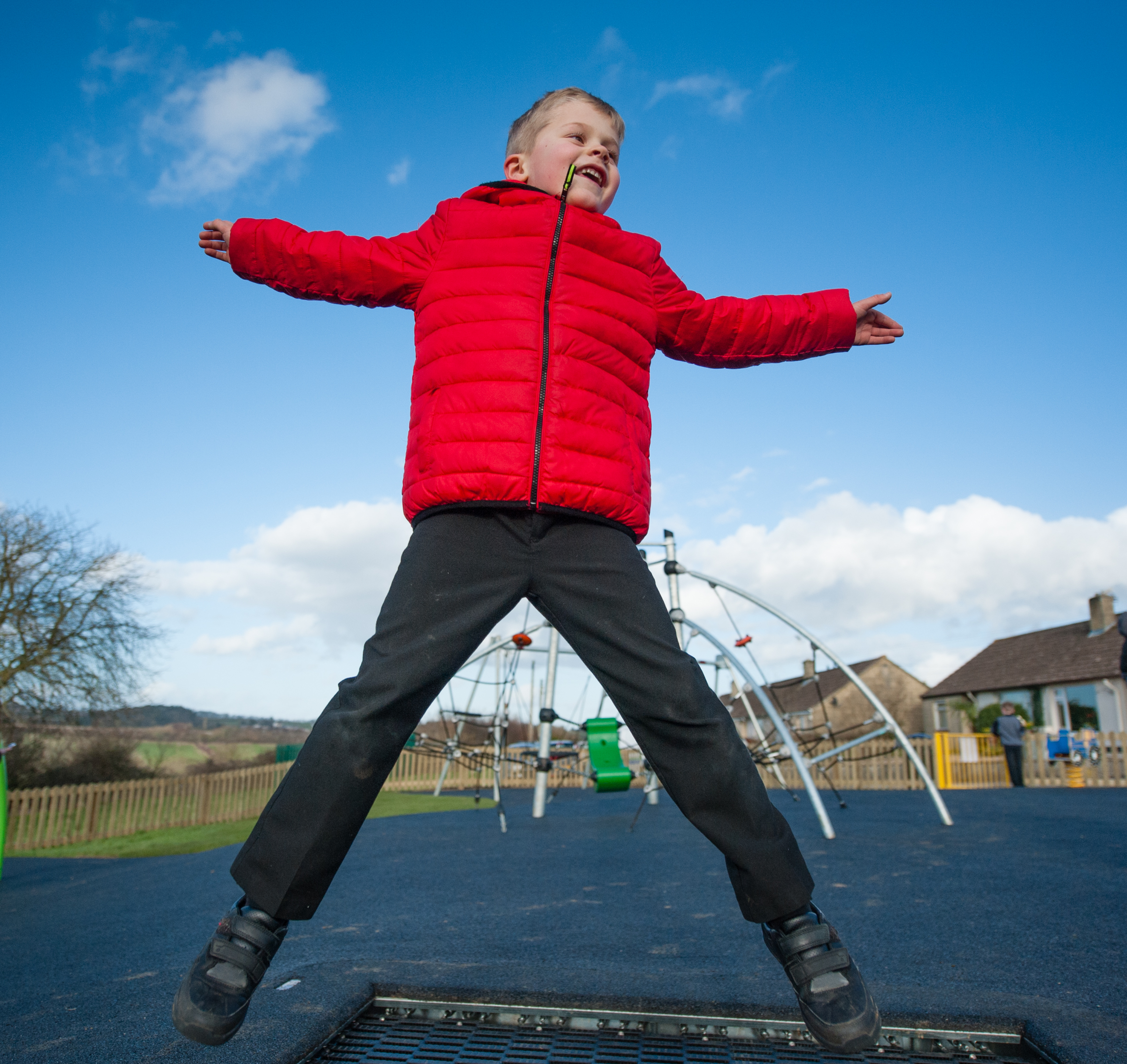 child using trampoline in park