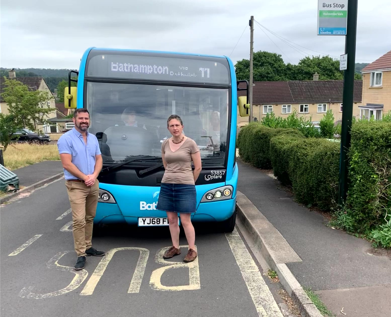 Councillor Kevin Guy (on the left) and Councillor Sarah Warren (on the right) next to a blue bus