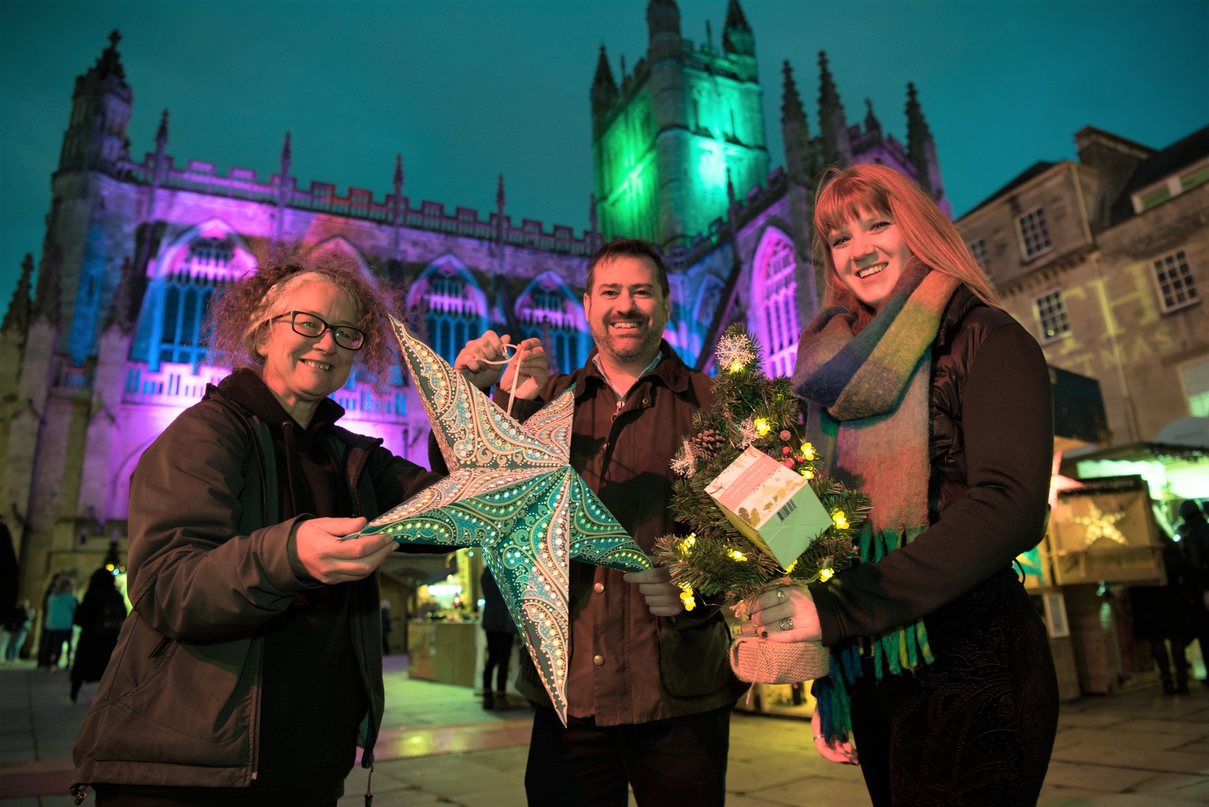 Jules Cooper from Paperstarlights, Cllr Kevin Guy, April Collins from the Leafy Tea Company in front of Bath Abbey at Bath Christmas Market