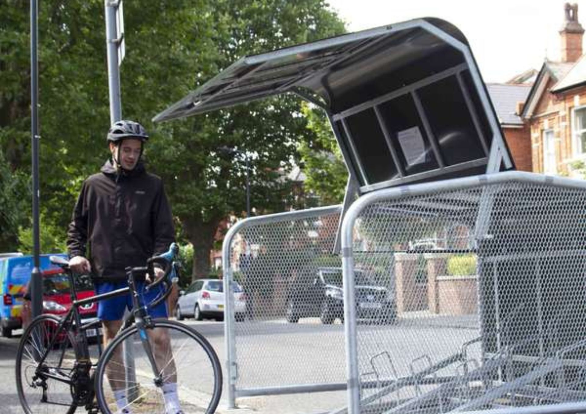 photo of a man with a bike standing next to an open cycle hangar