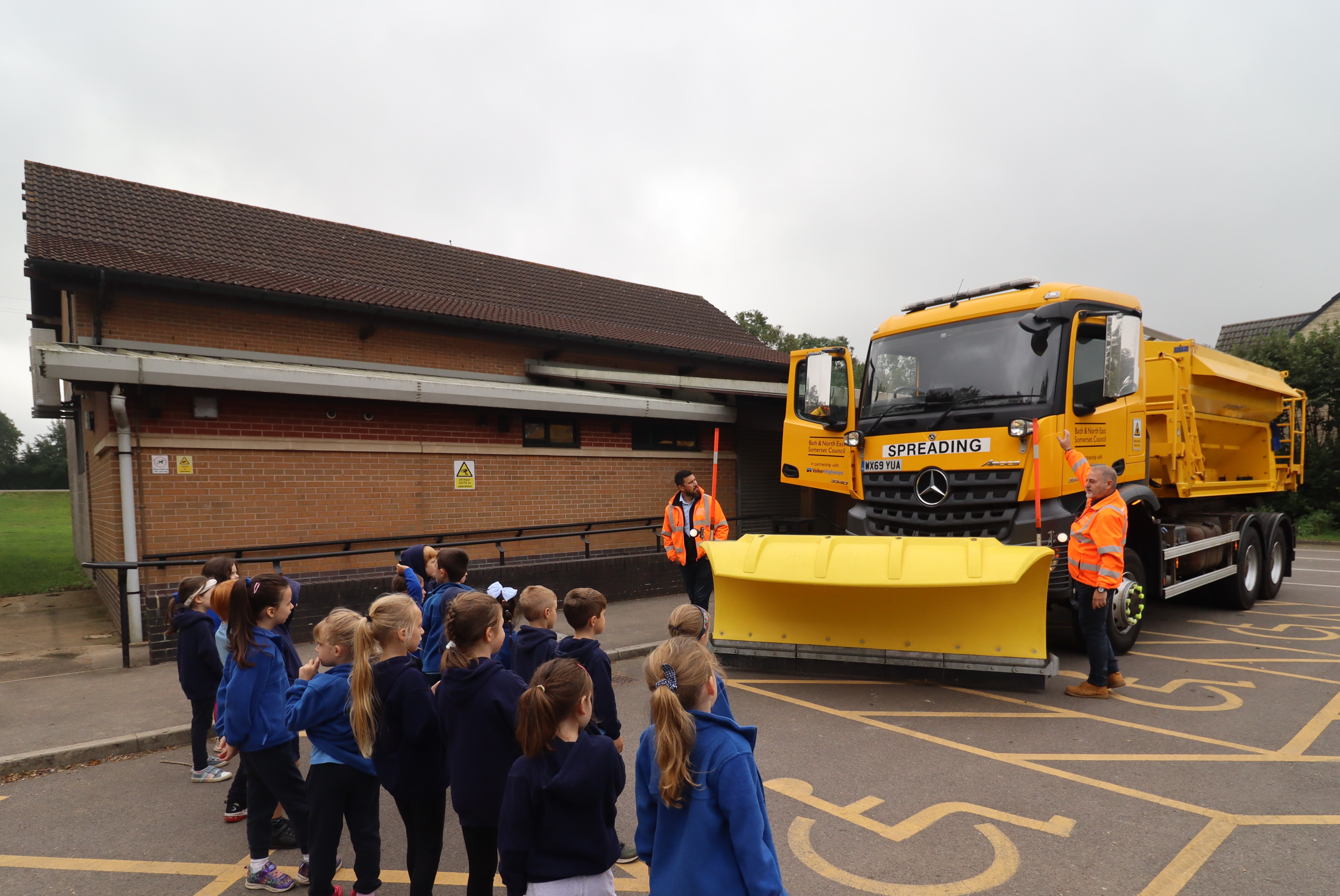 VolkerHighway staff speaking to pupils stood in front of gritting lorry