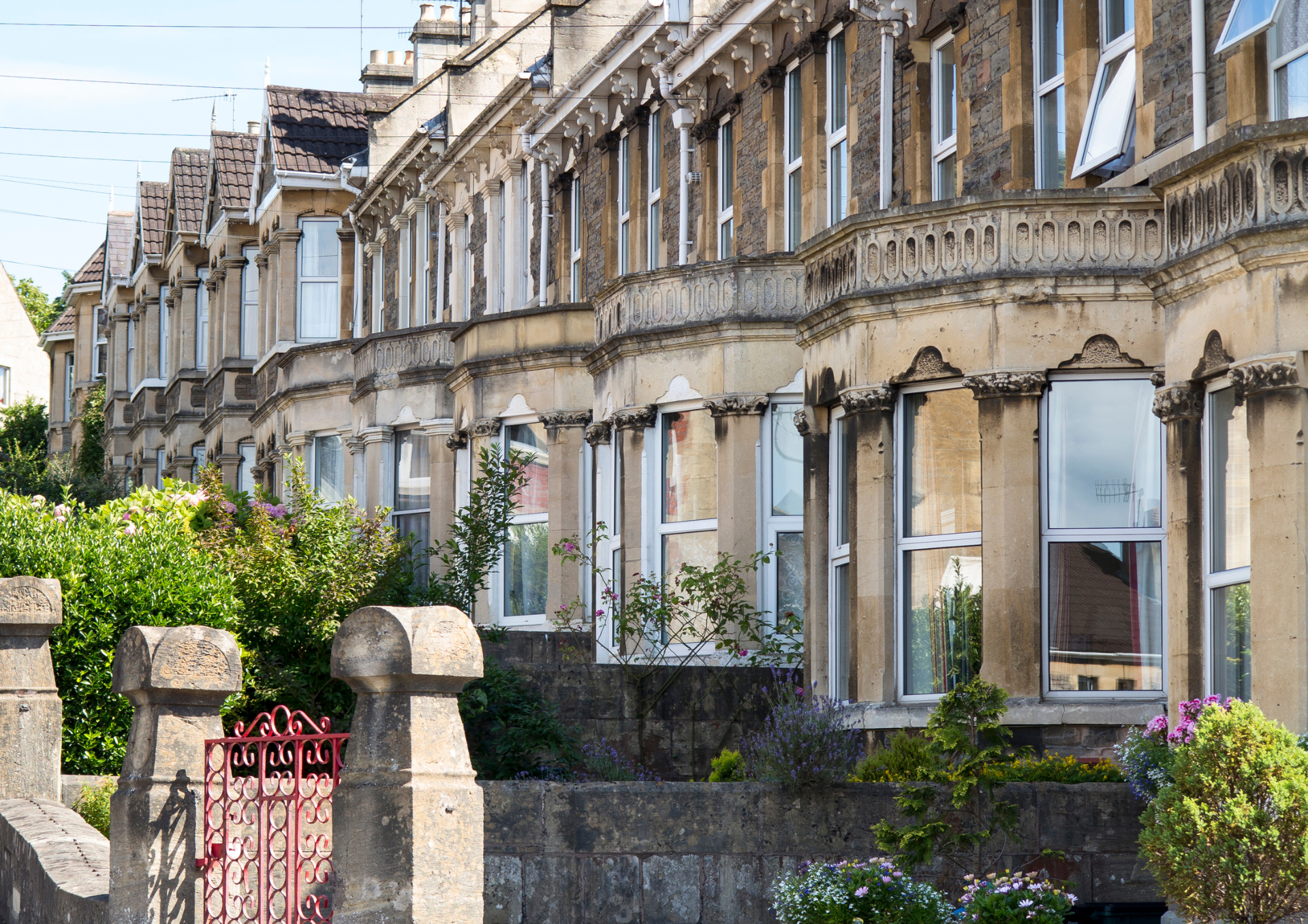 a photo of a row of two-storey terraced houses with bay windows on the lower floor