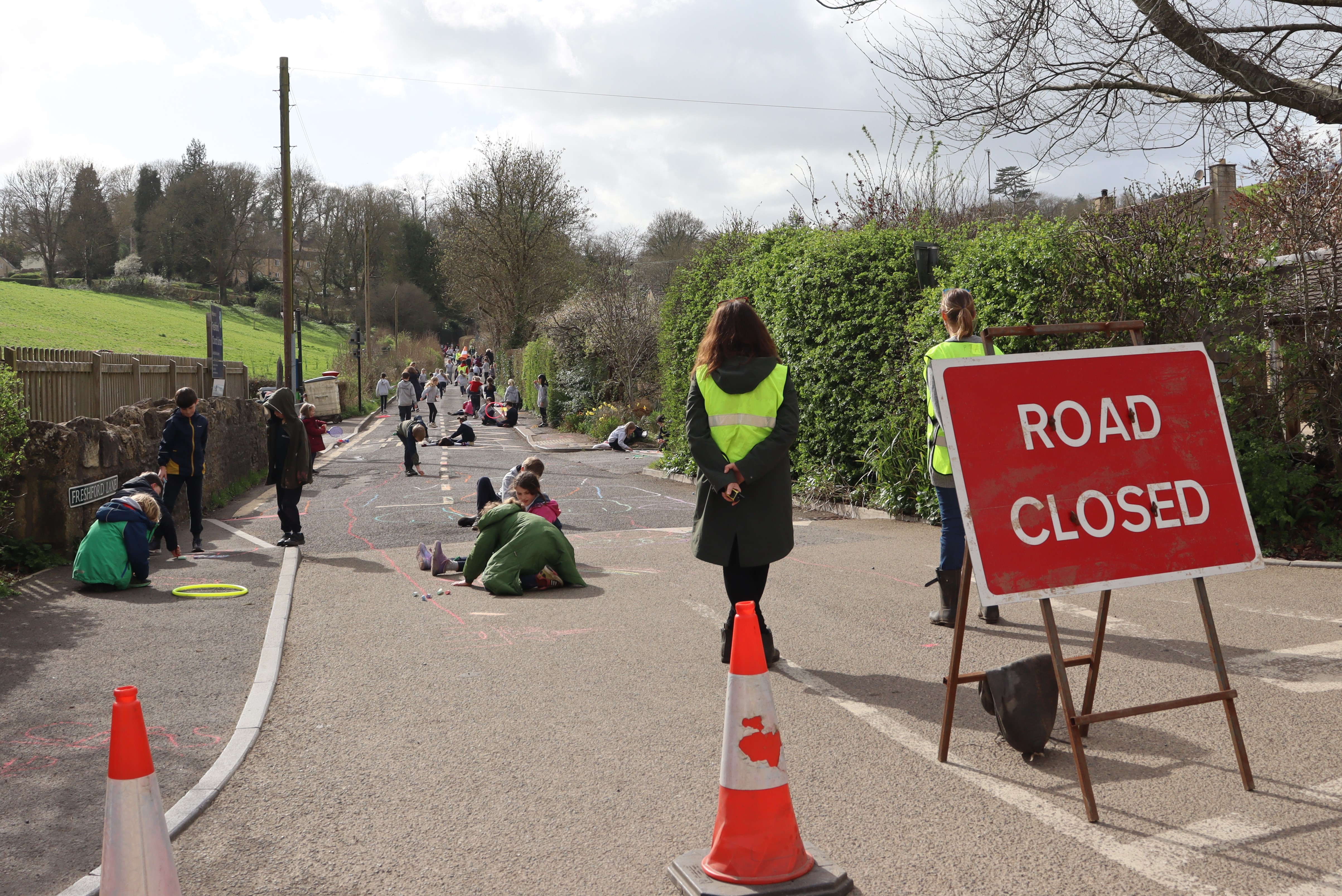 The road outside of Freshford School closed off with children playing on it. 