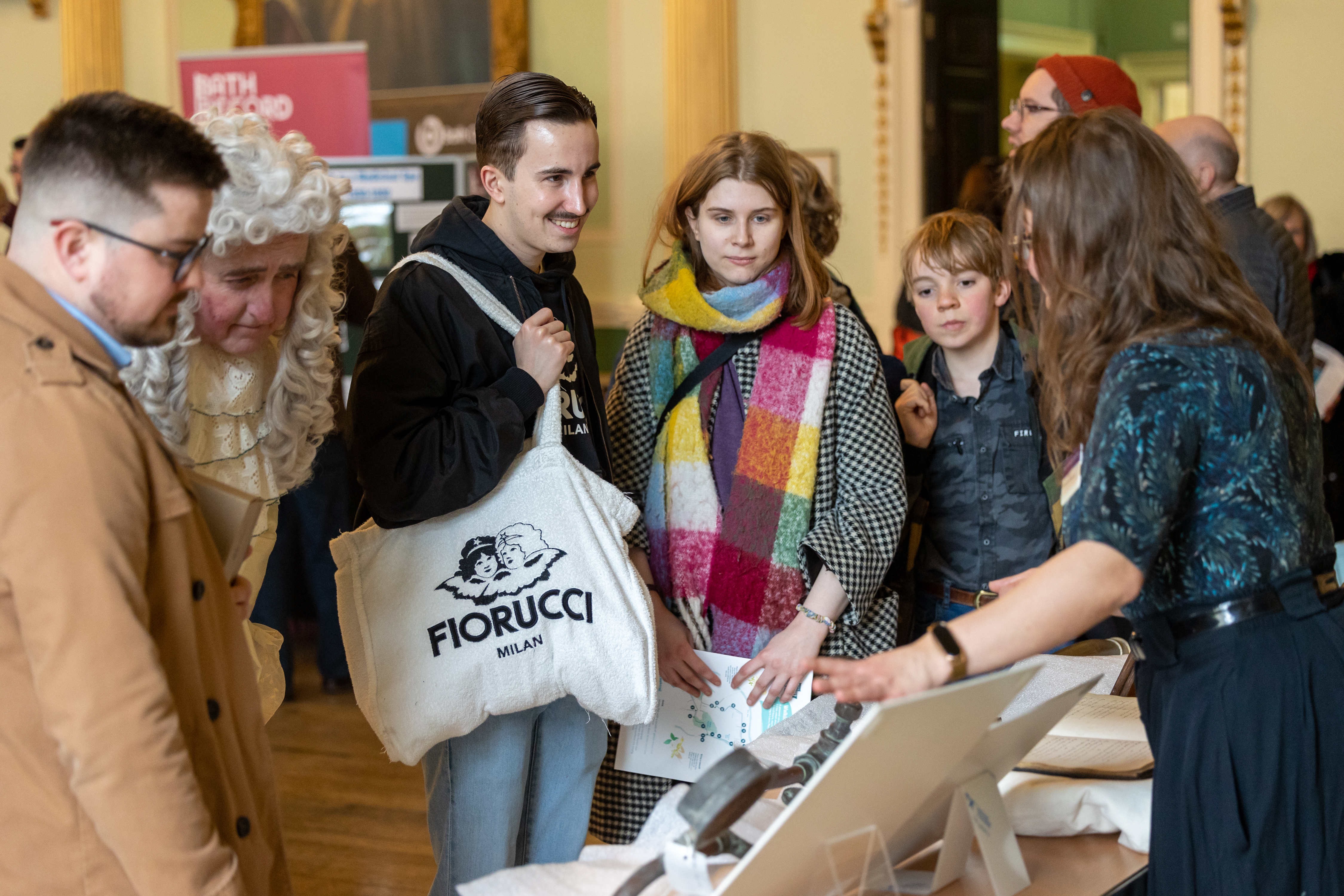A group of people looking at objects at a World Heritage Day stall in the Guildhall.