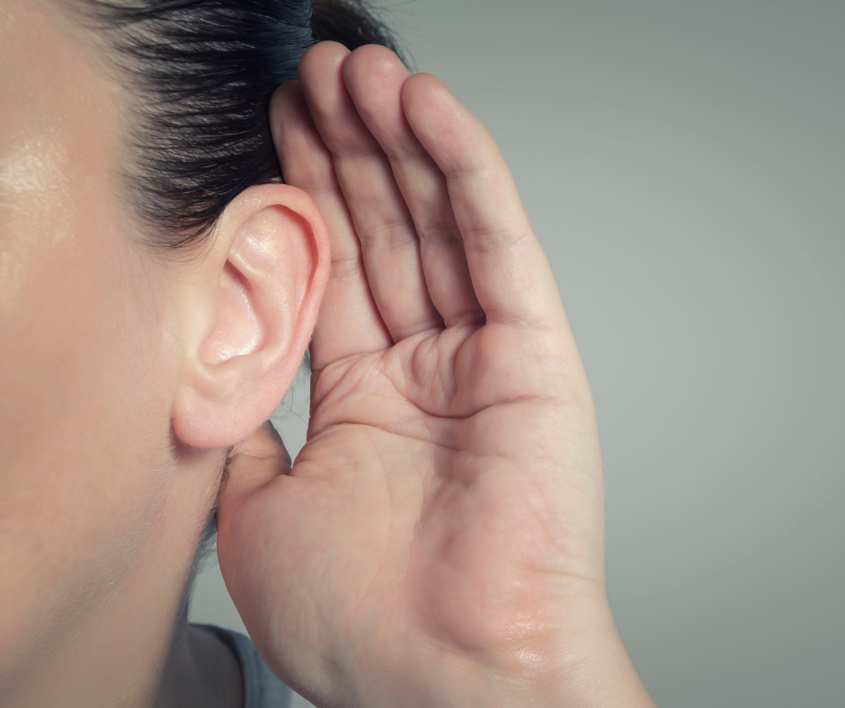 Person holds hand to their ear to listen