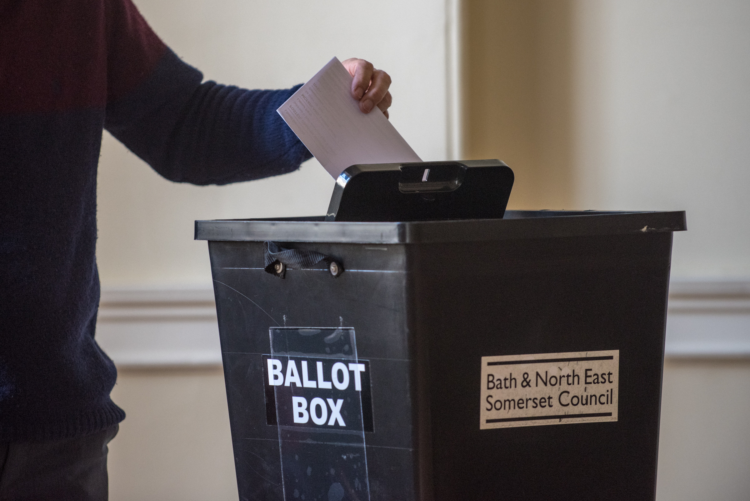 picture shows a ballot box with a person posting into it