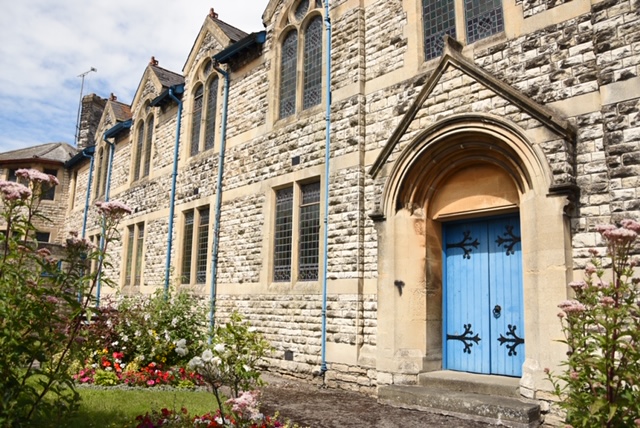 A side view of Trinity Church in Radstock with a light blue entry double door