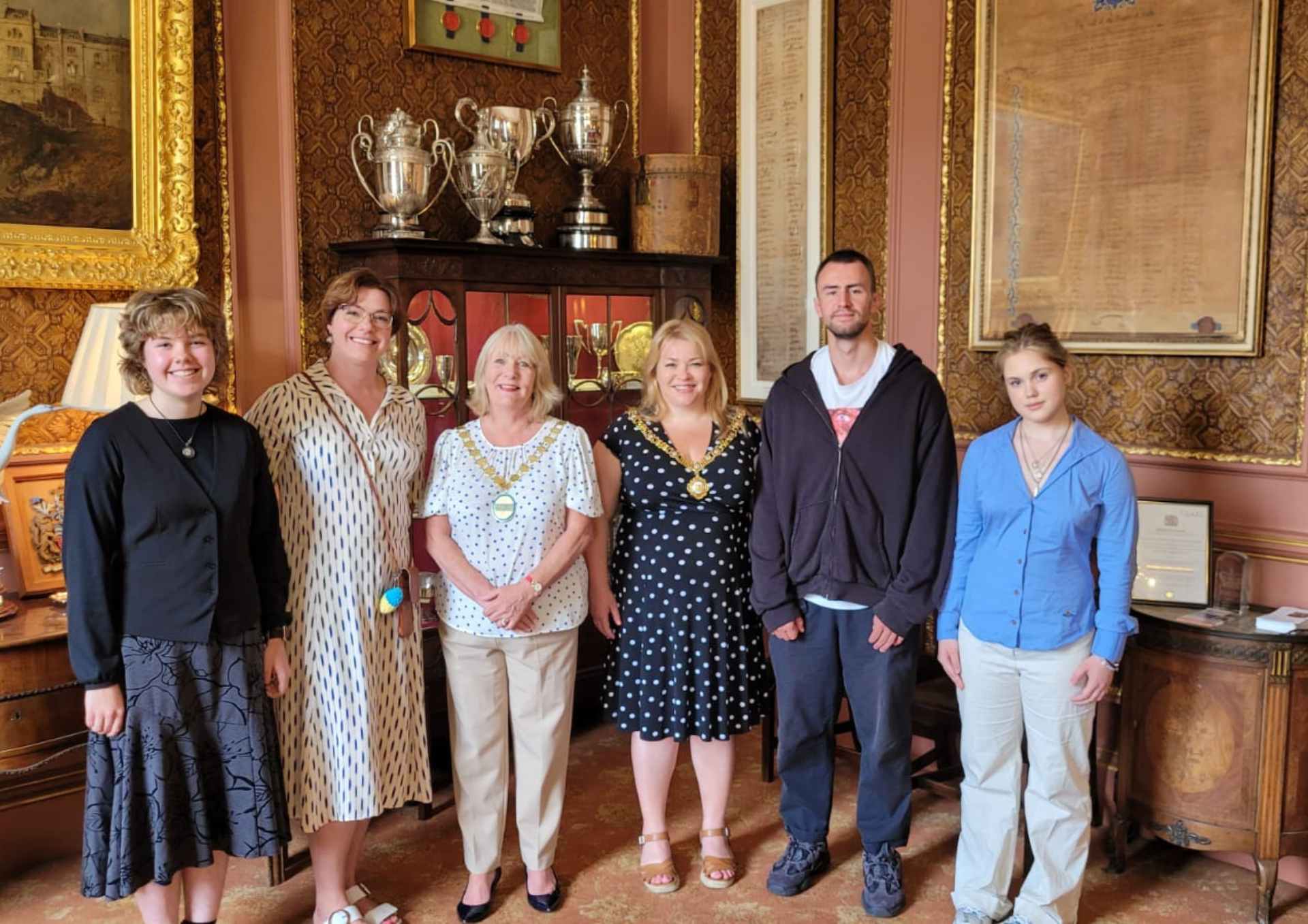 a photo of a group of five women and one man. Two of the women are wearing chains of office around their necks. 