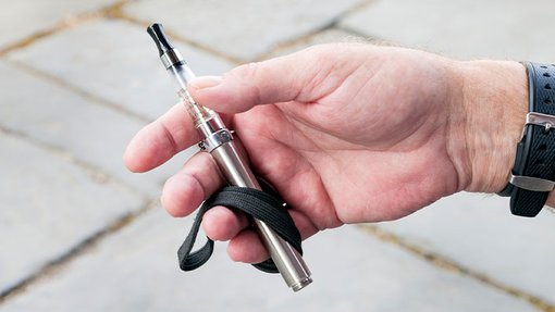 Close up of a hand holding a refillable vape