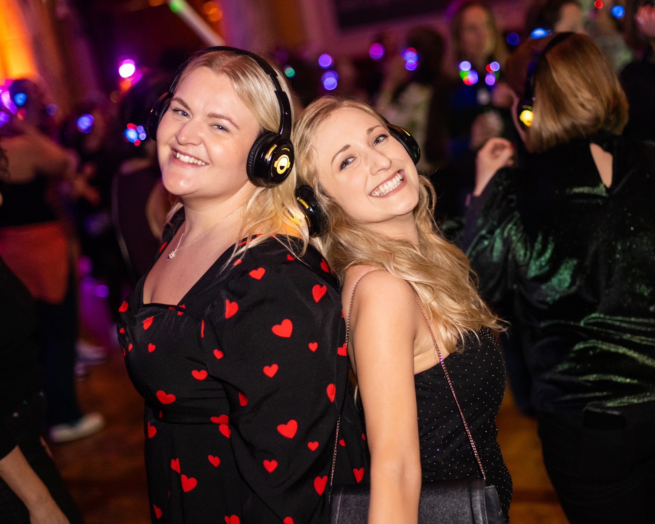 Two young women wearing headphones at a Silent Disco at the Roman Baths