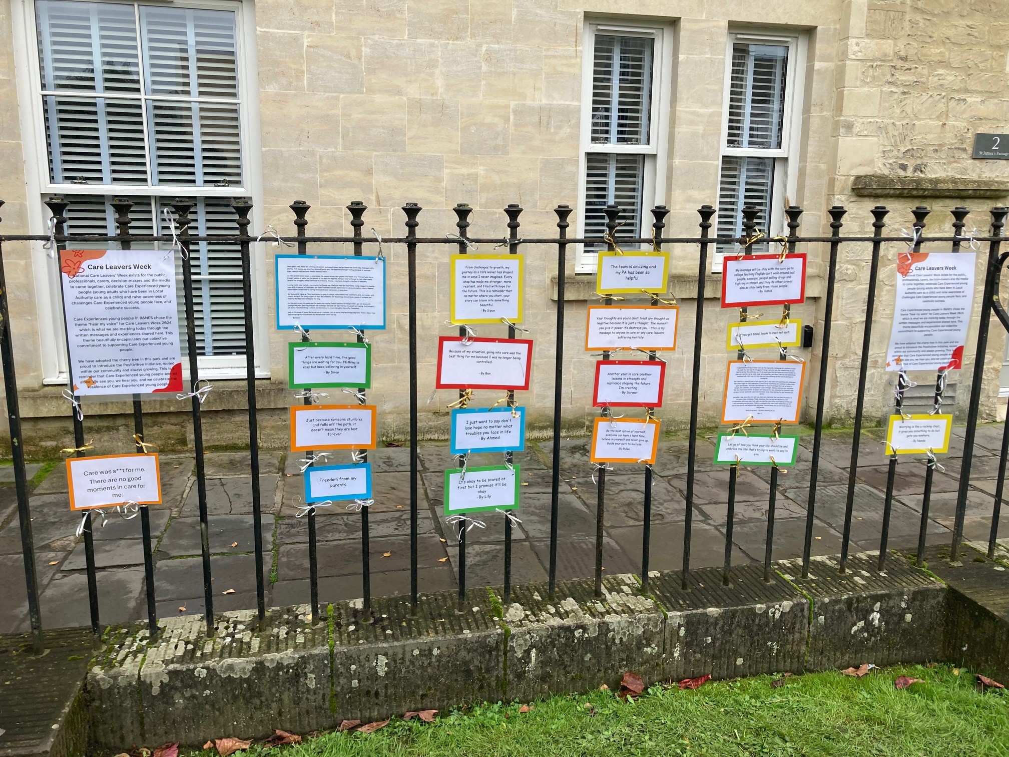 photo shows signs with messages from care leavers hanging on railings 