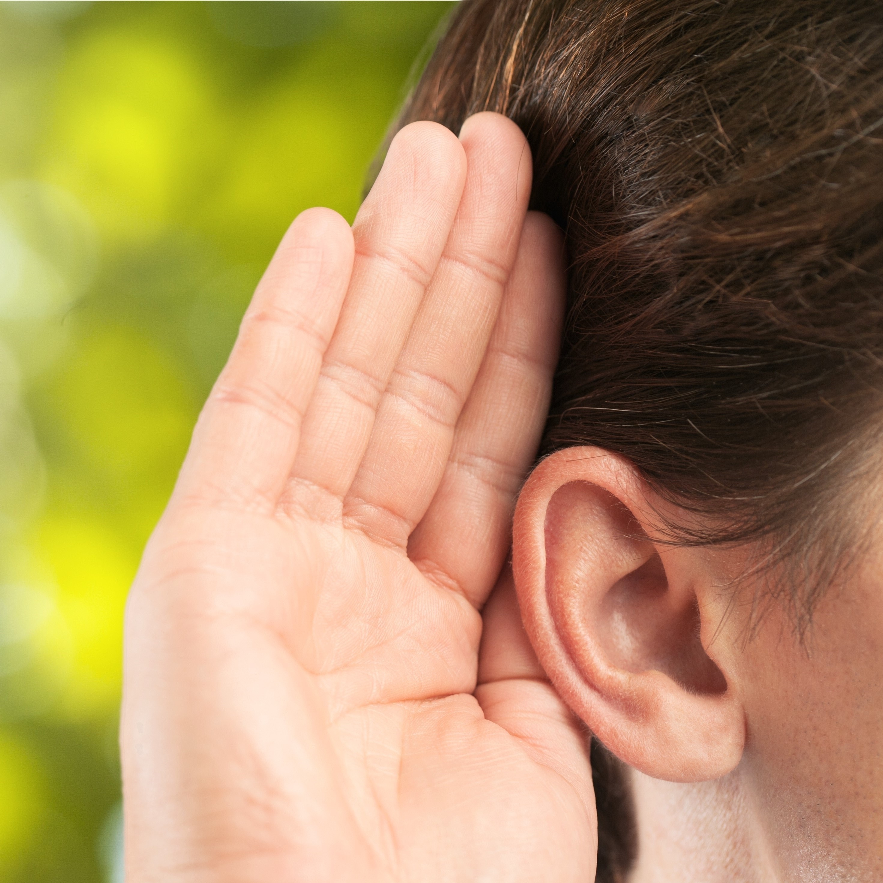 Person holds hand to their ear to listen