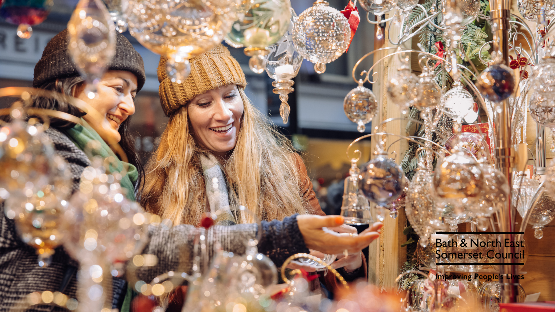 Two women looking at decorations at Bath Christmas Market. 