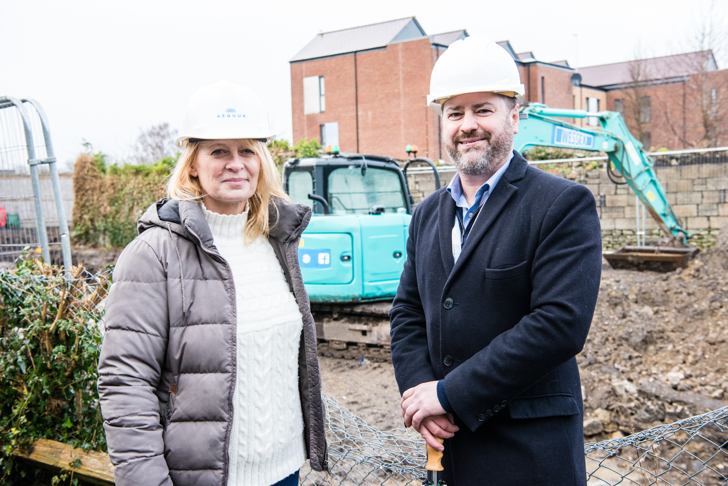 Pictured left to right at the Danes Lane, Keynsham construction site infront of a digger are Sally Higham, Aequus chair and Councillor Kevin Guy leader of Bath and North East Somerset Council    