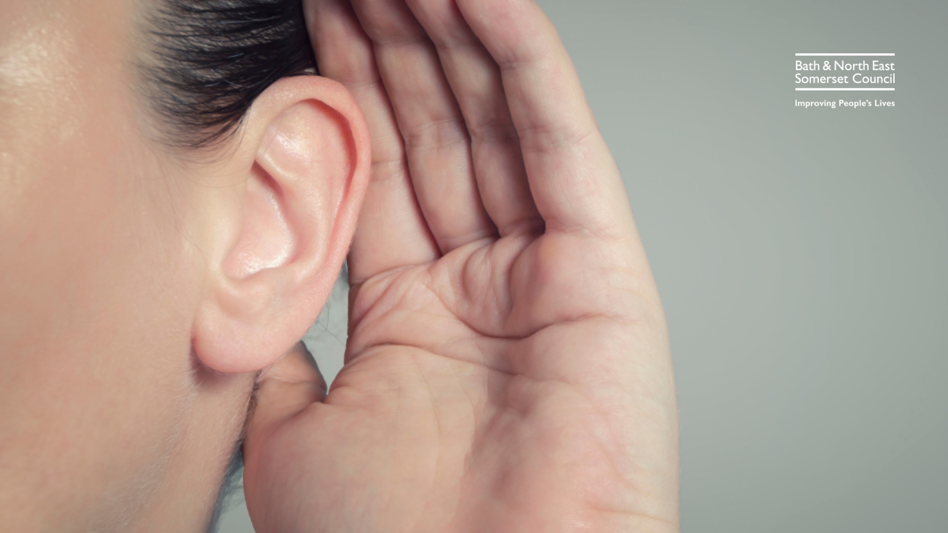 Person holds hand to their ear to listen