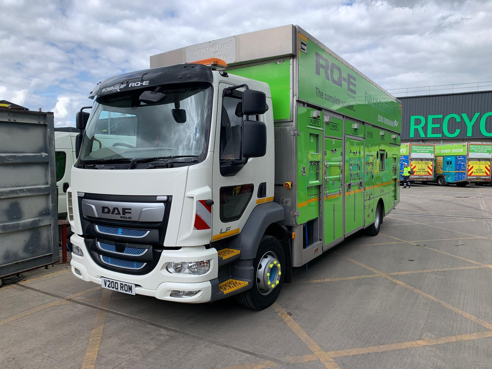 Electric recycling truck parked at recycling depot