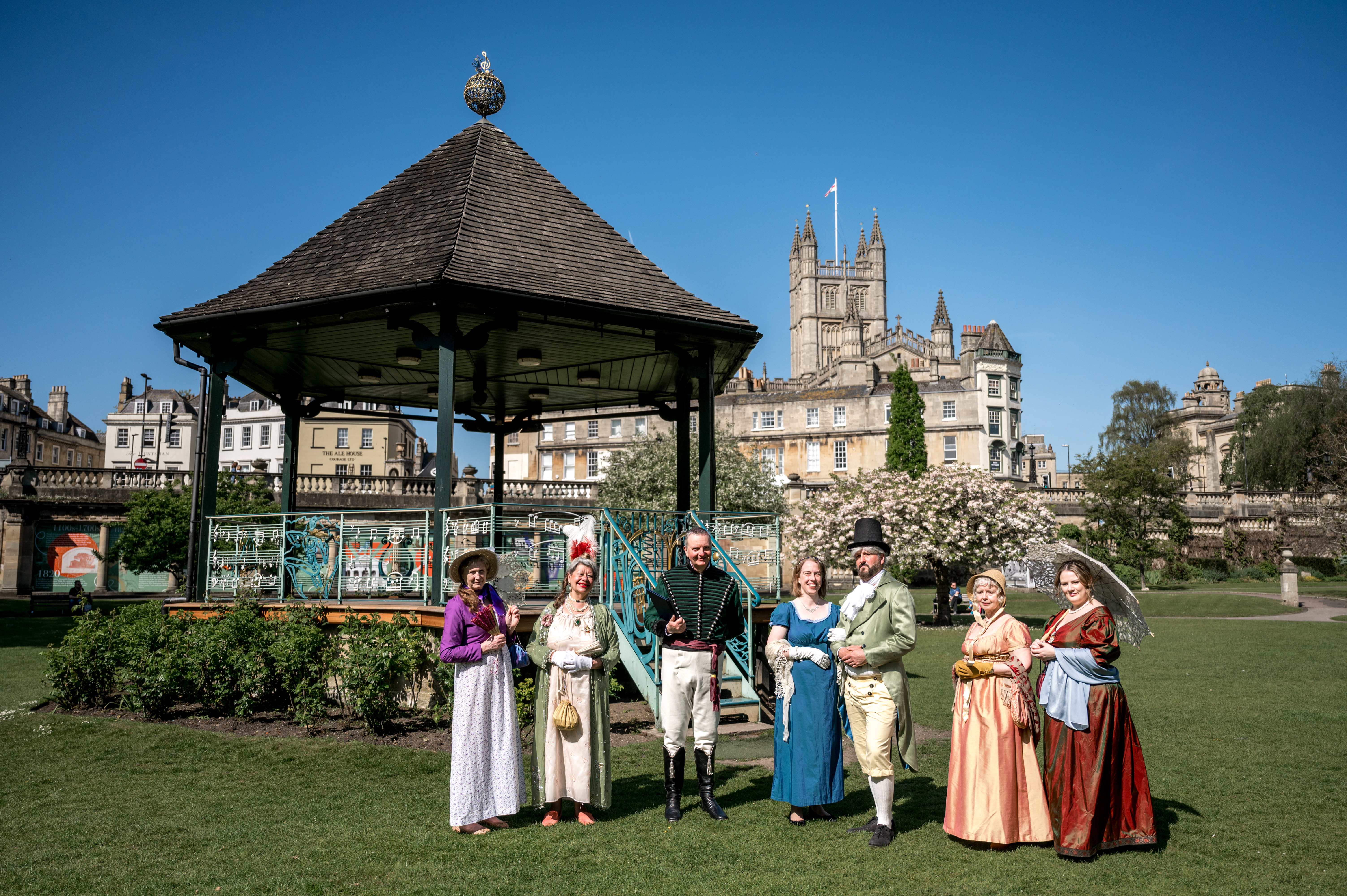 People stand in period costume at the Bandstand at Parade Gardens in Bath