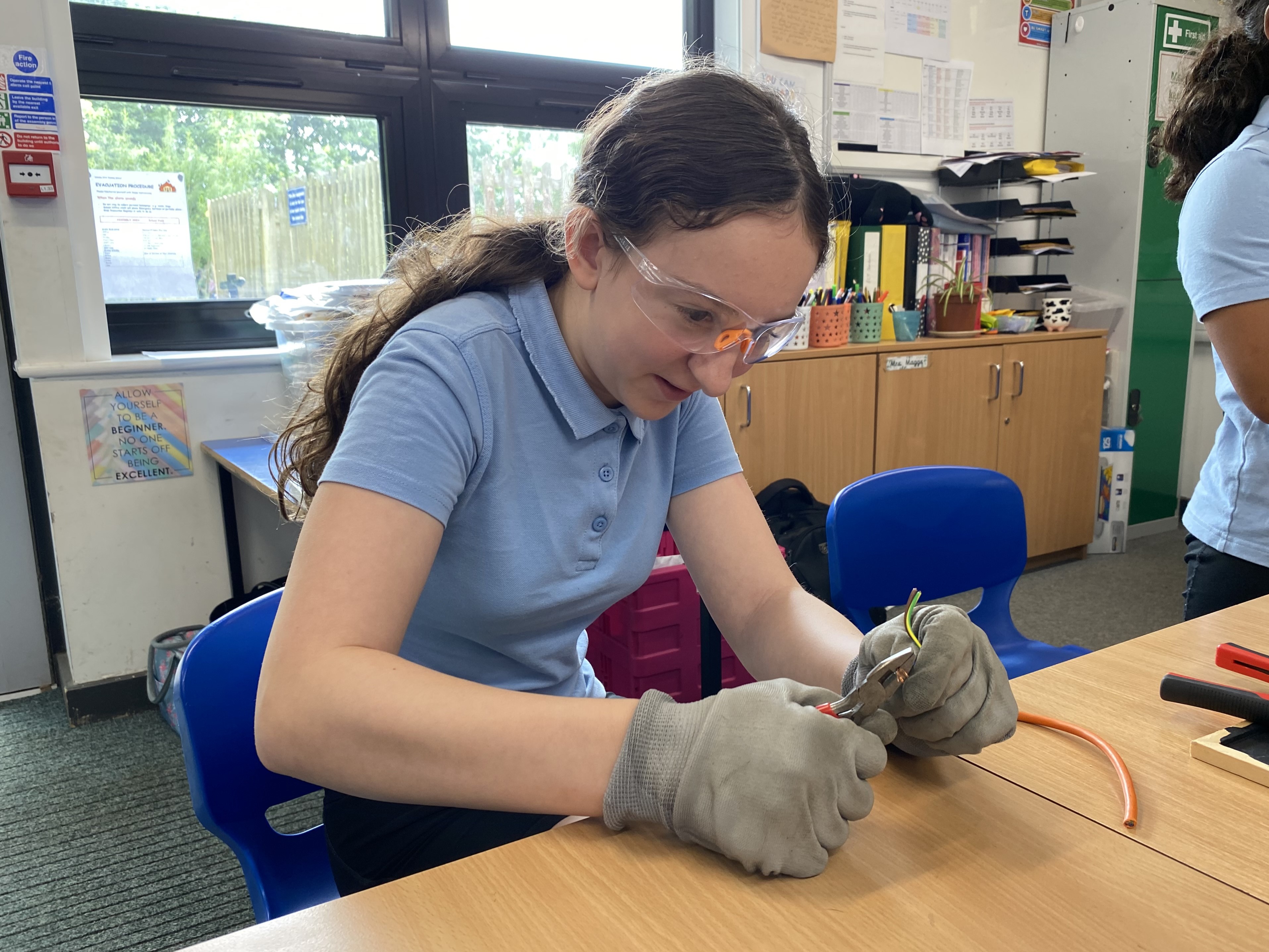 Child uses tools to strip wire for recycling