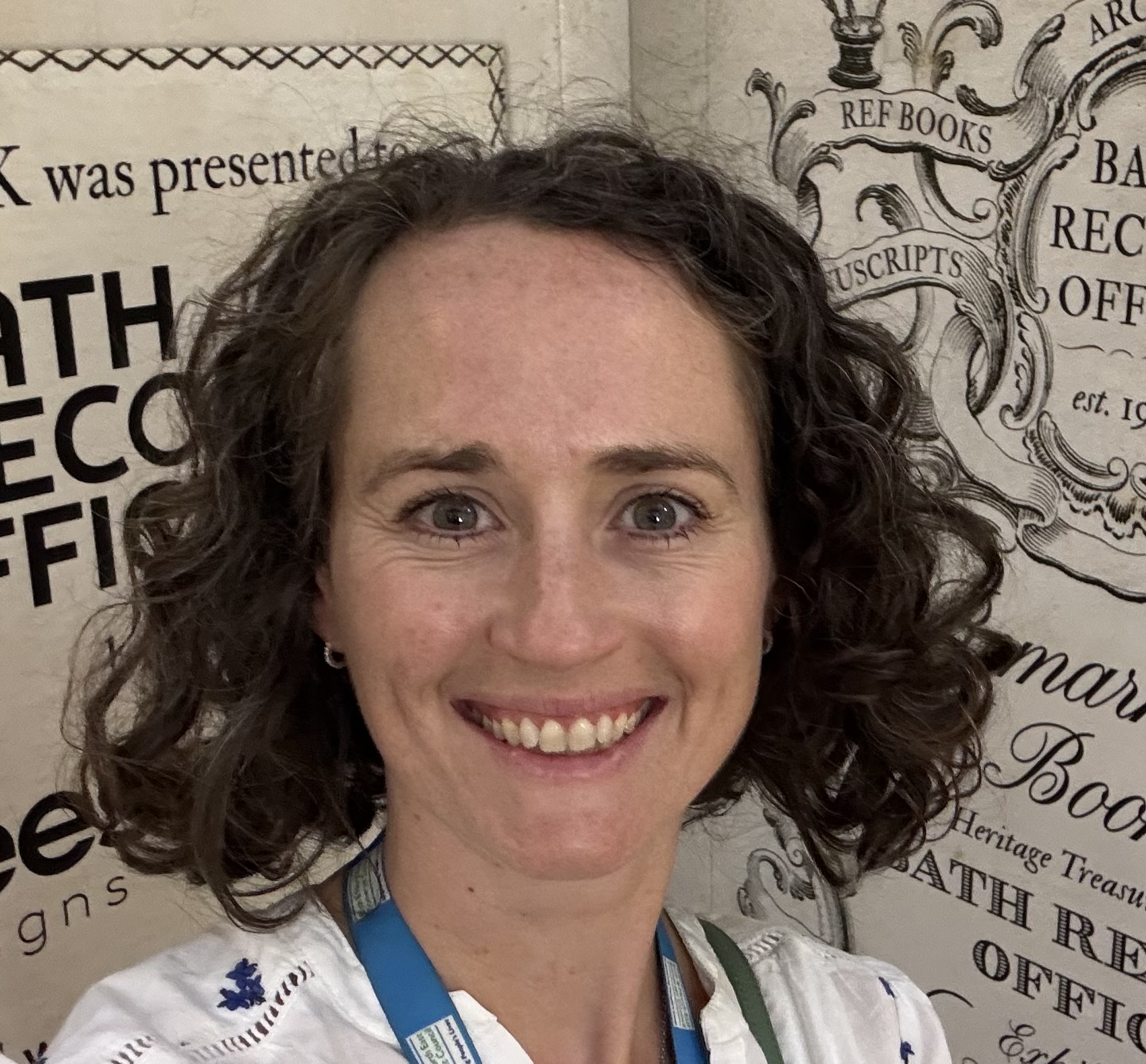Head and shoulders shot of Sophie Broadfield with Bath Record Office posters in the background