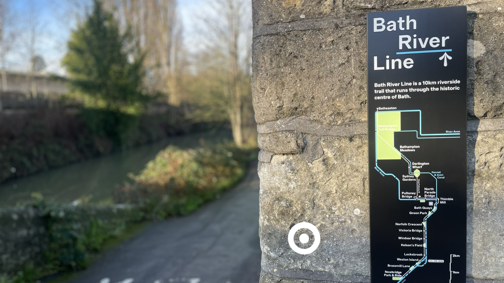 a sign showing the detail of the river line path. In the background the river