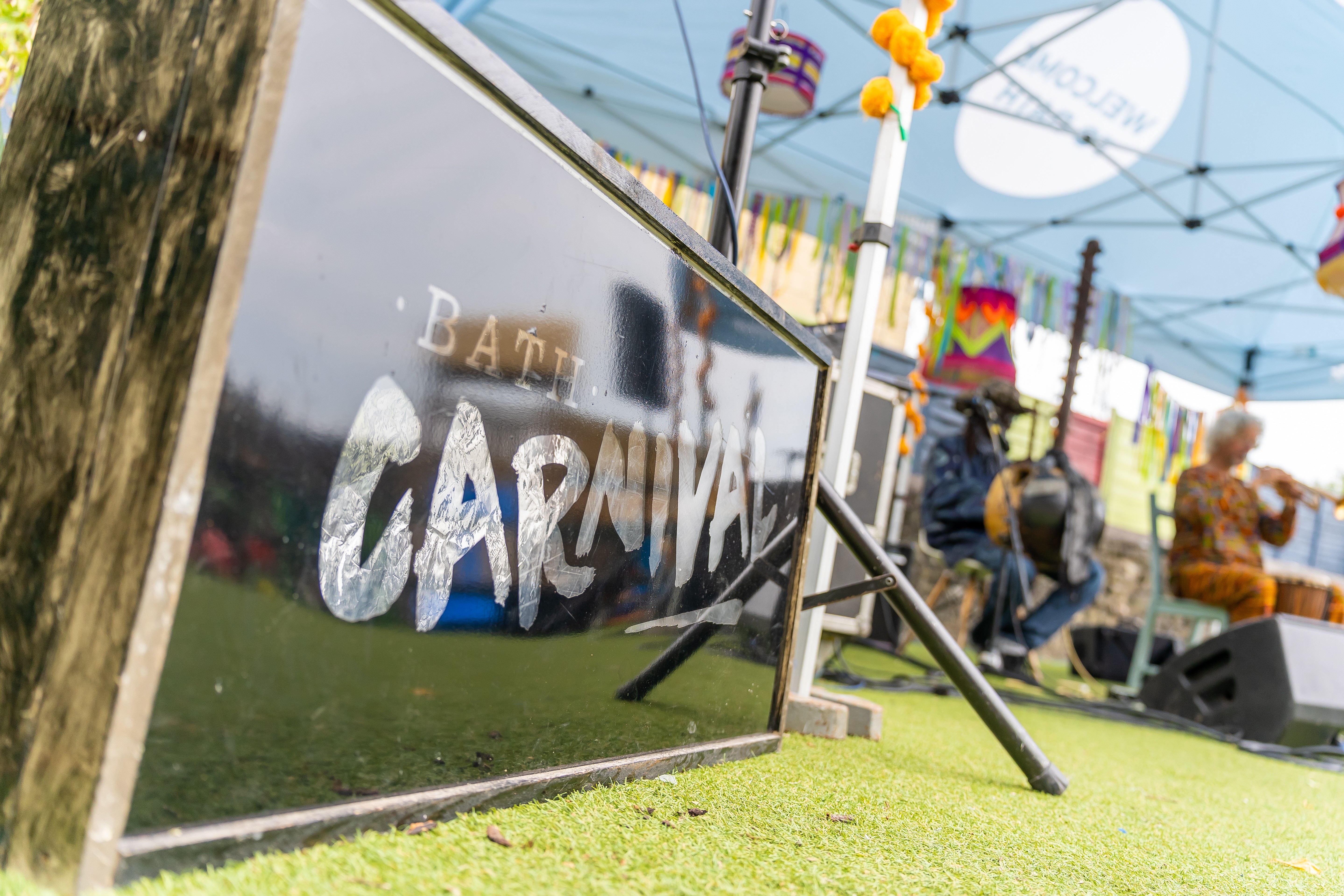 sign saying Bath Carnival with band on a stage in the background