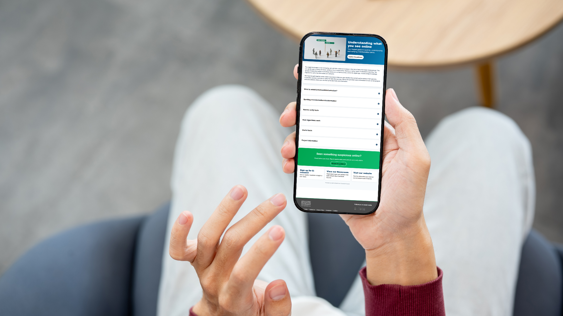 image shows someone sitting down looking at their mobile phone which shows the new webpage  