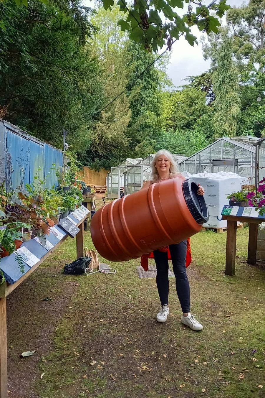 A person holds a water barrel at an allotment