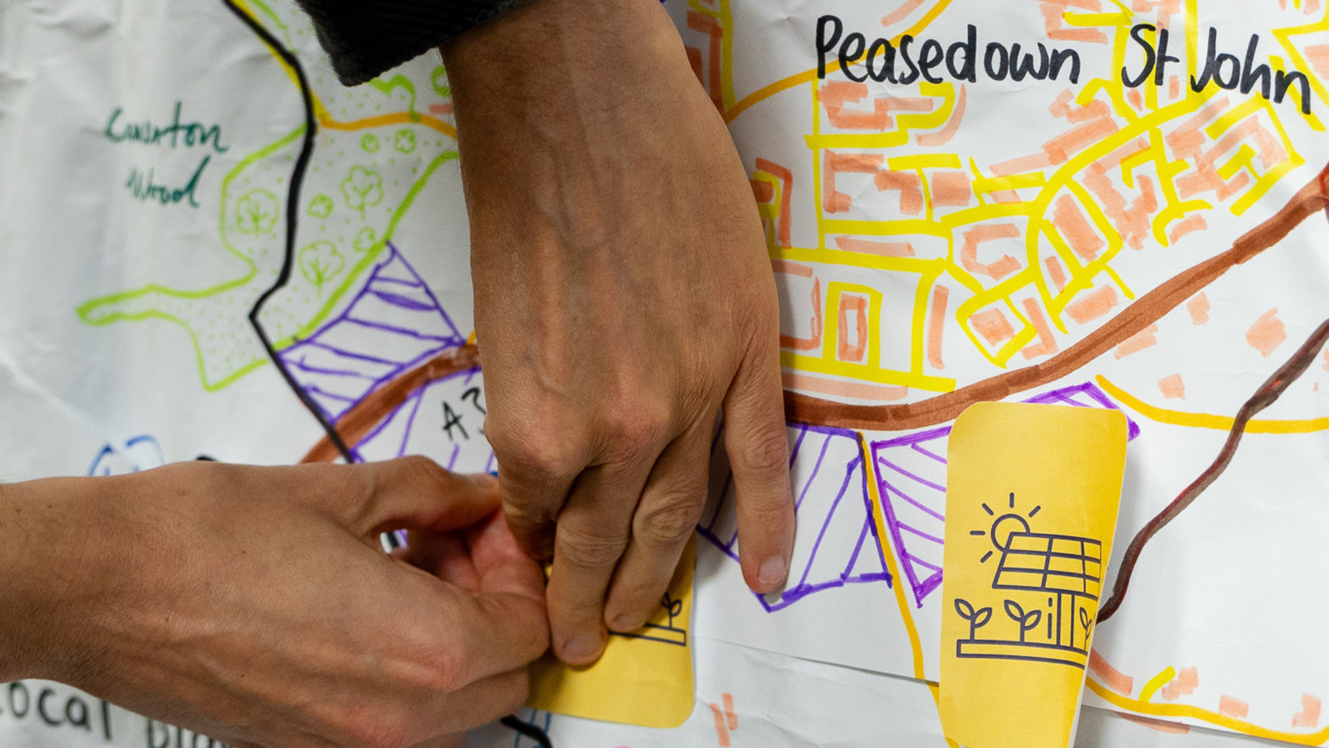 hands of someone pinning notes onto a map
