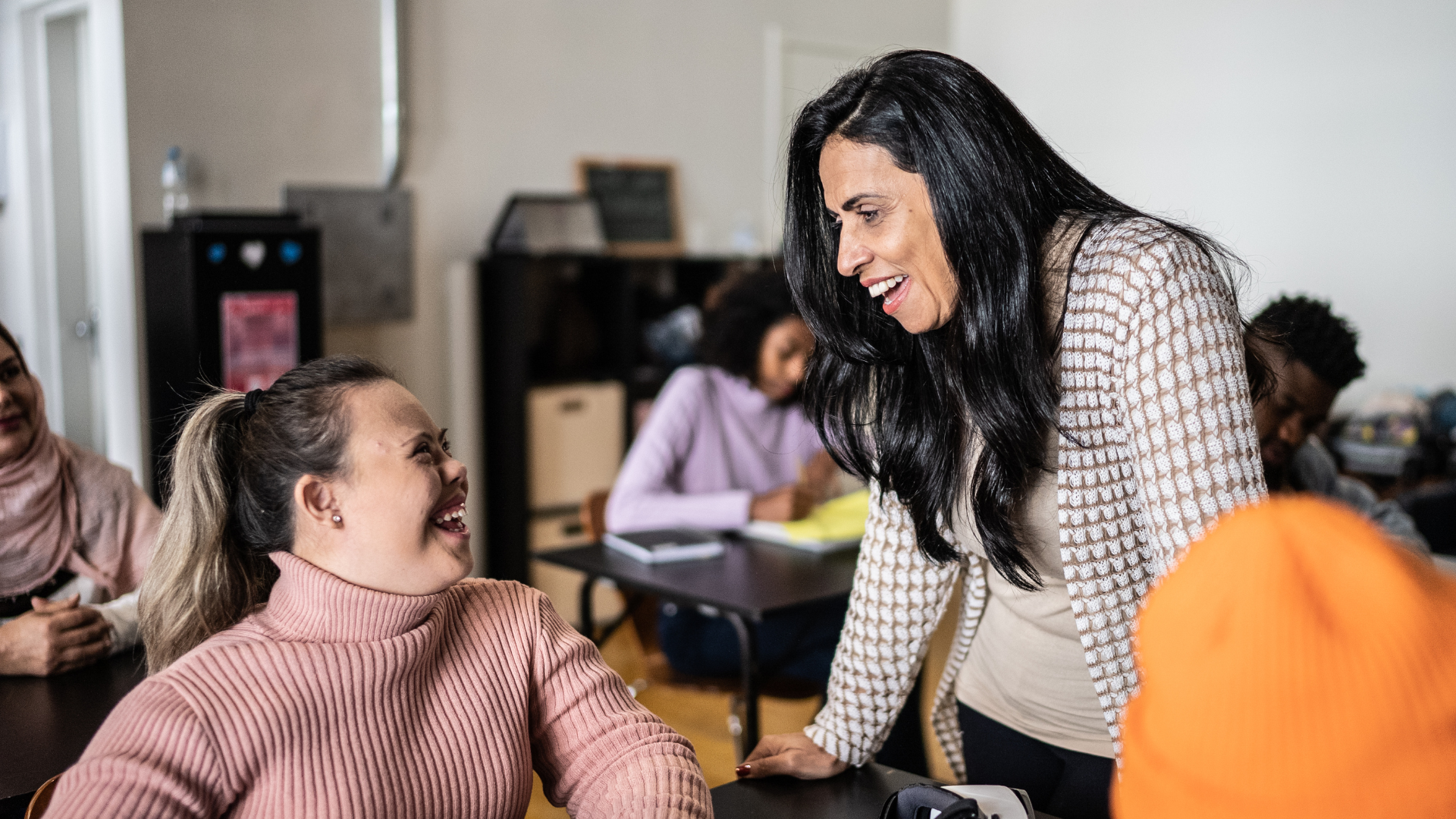 An adult and a child smile at each other as they talk.