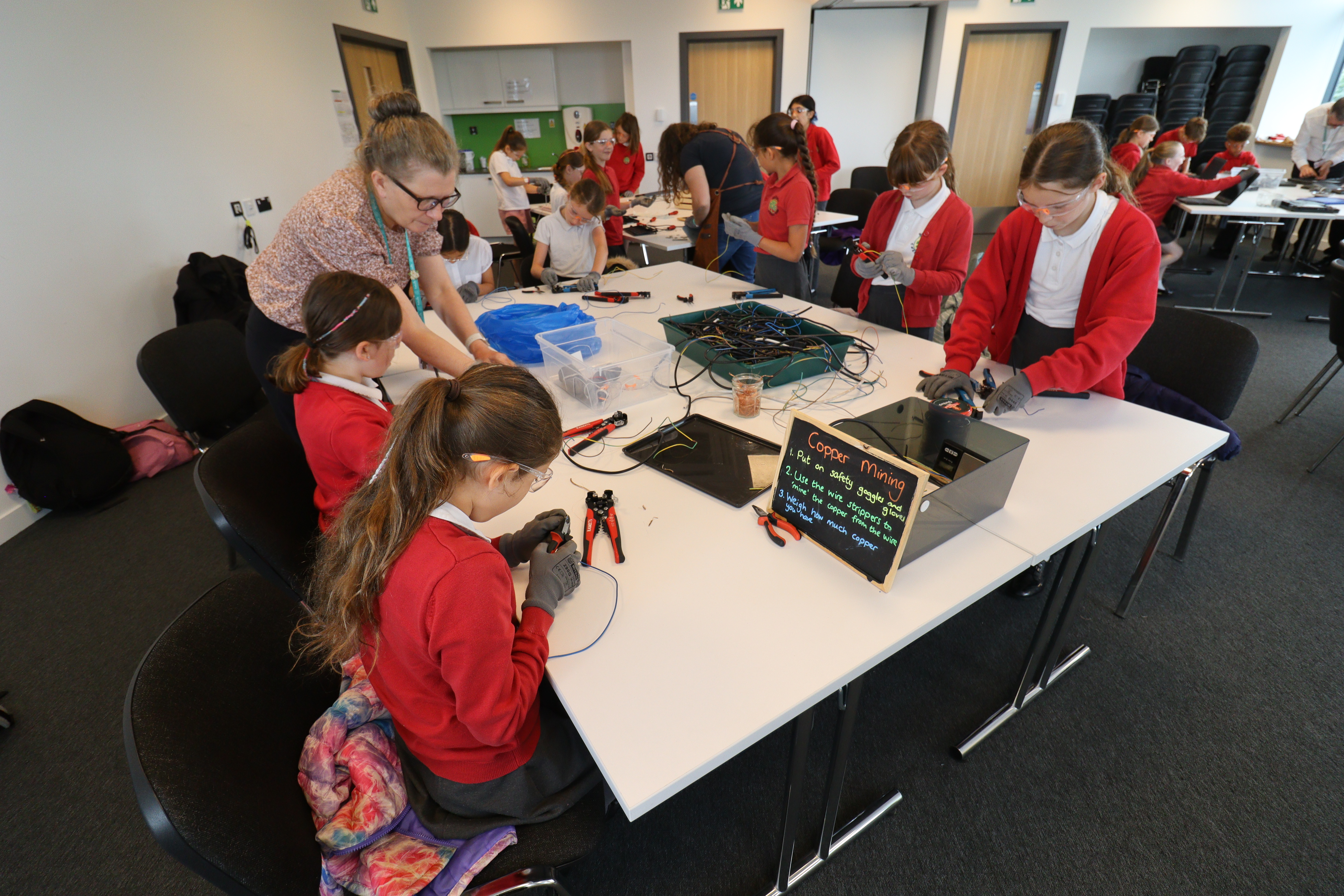 Primary school children in uniform sit at a table 