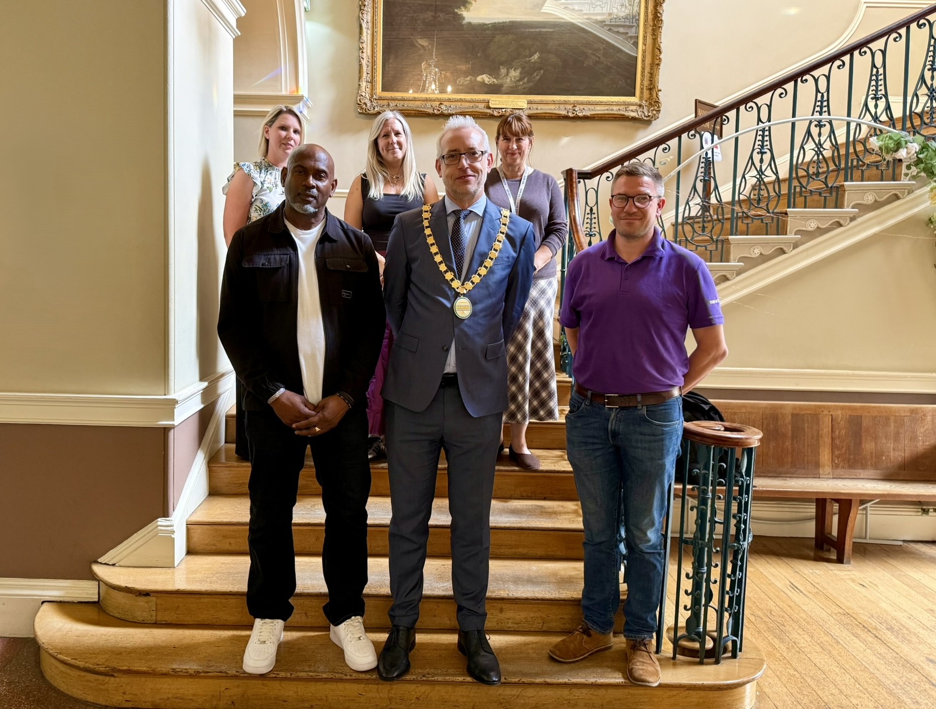 A group of people stand on a staircase