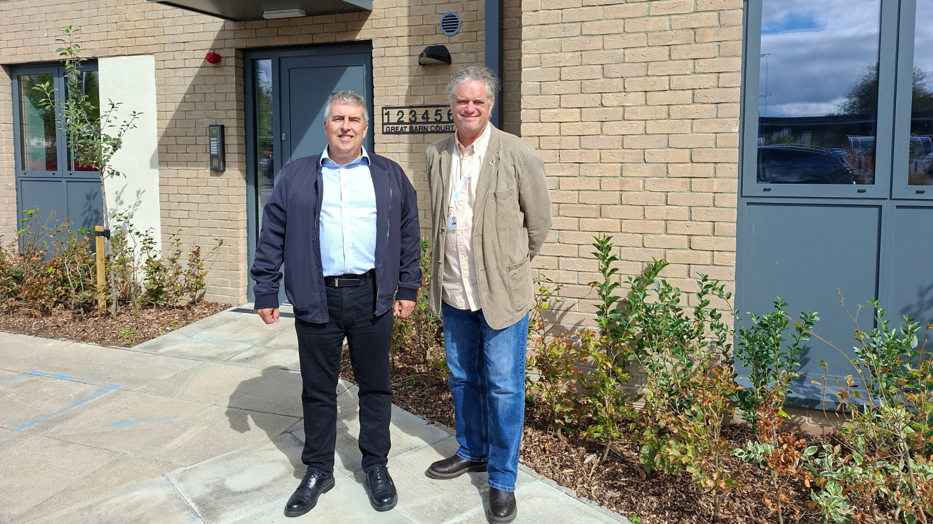 two men standing in front of a building 